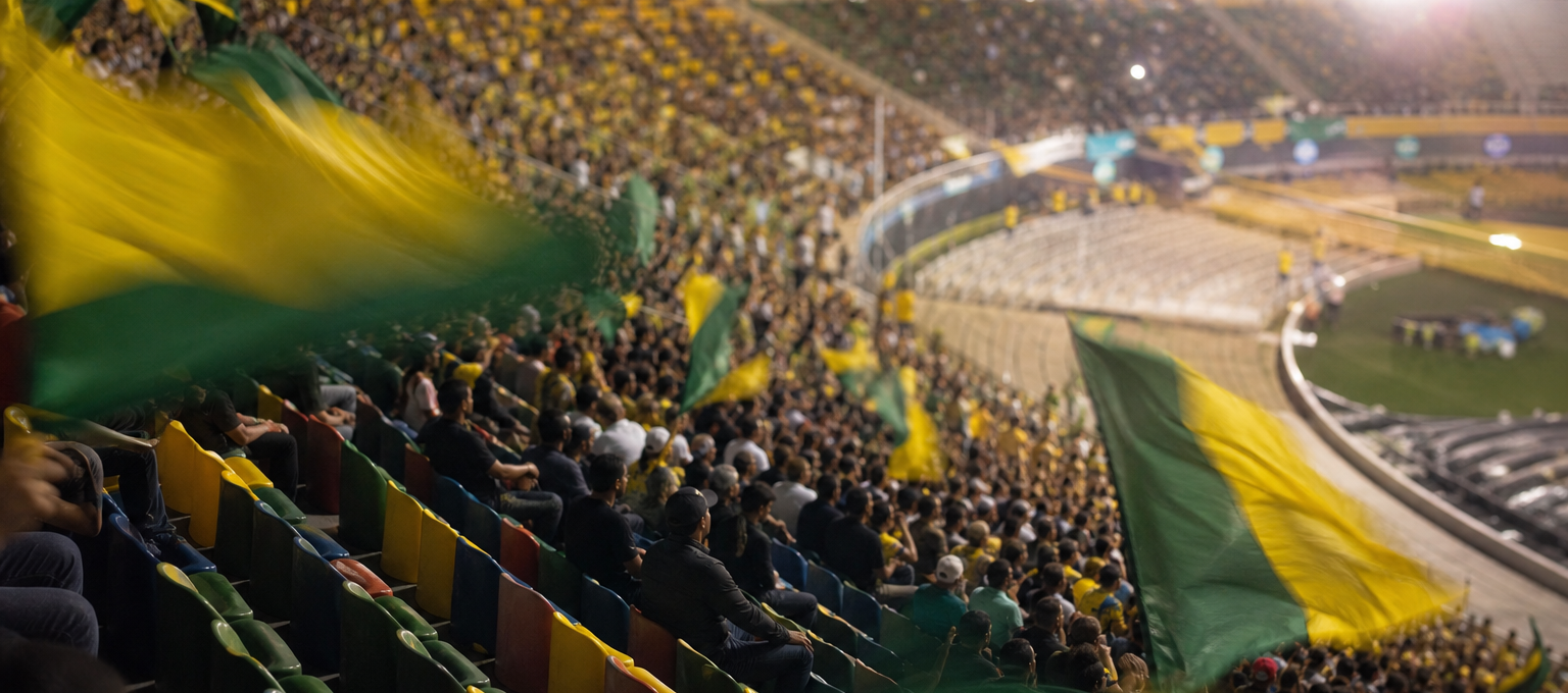 Arquibancadas cheias com bandeiras verde e amarelo em um estádio, sem marcas visíveis.
